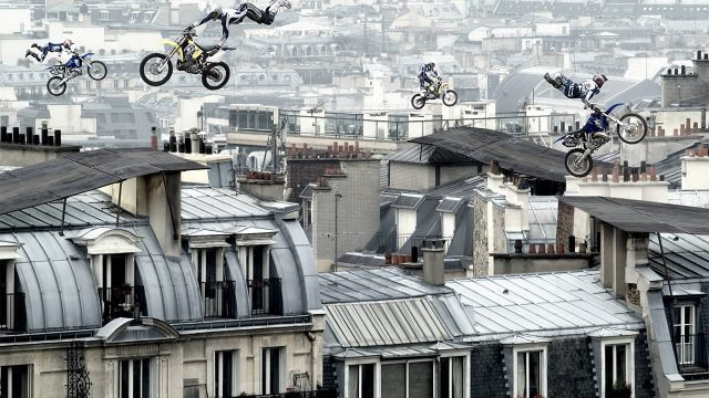 Visualisation of stunt bikes performing acrobats in the sky above a city