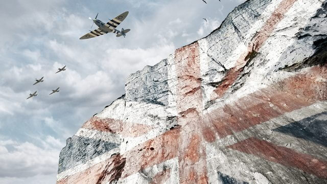 Image of union jack displaying on white cliffs of Dover with spitfire aeroplanes flying over